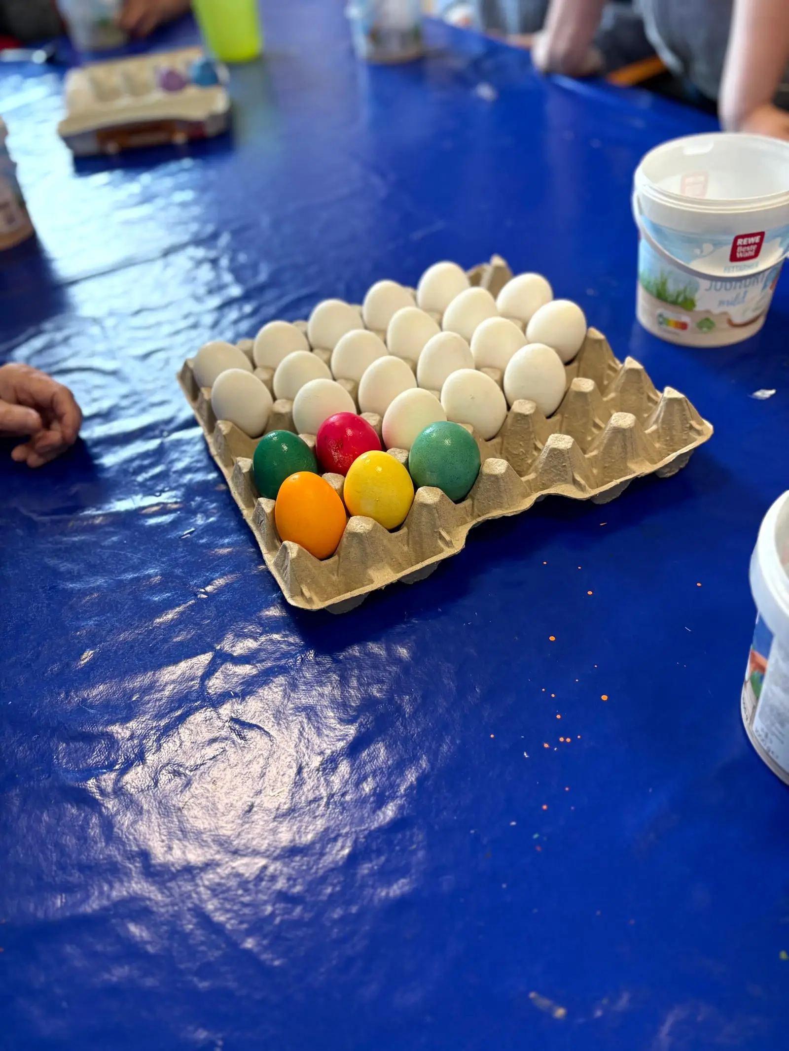 Ein Eierkarton mit frisch gefärbten roten, grünen und gelben Ostereiern