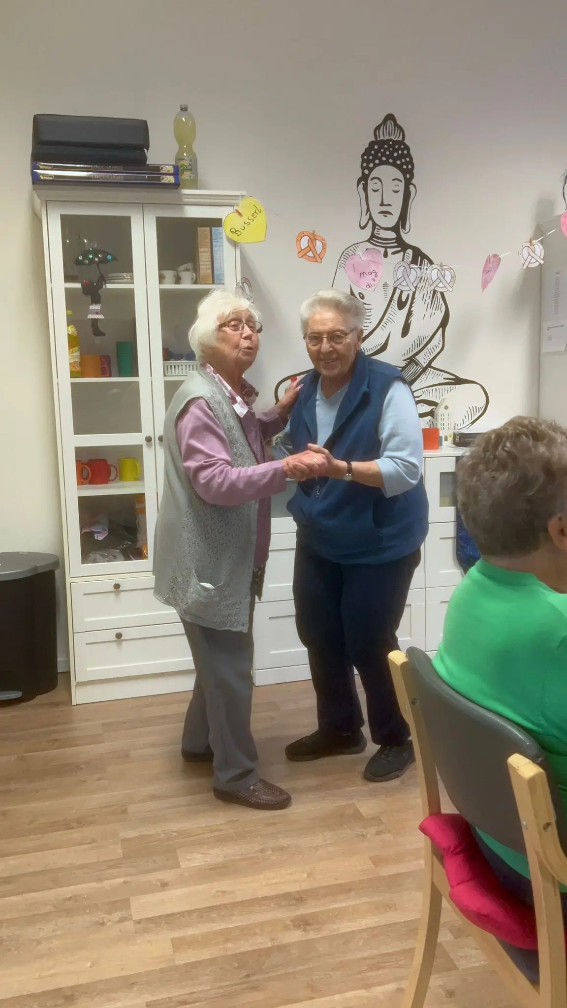 Zwei Gäste tanzen Hand in Hand im Aufenthaltsraum