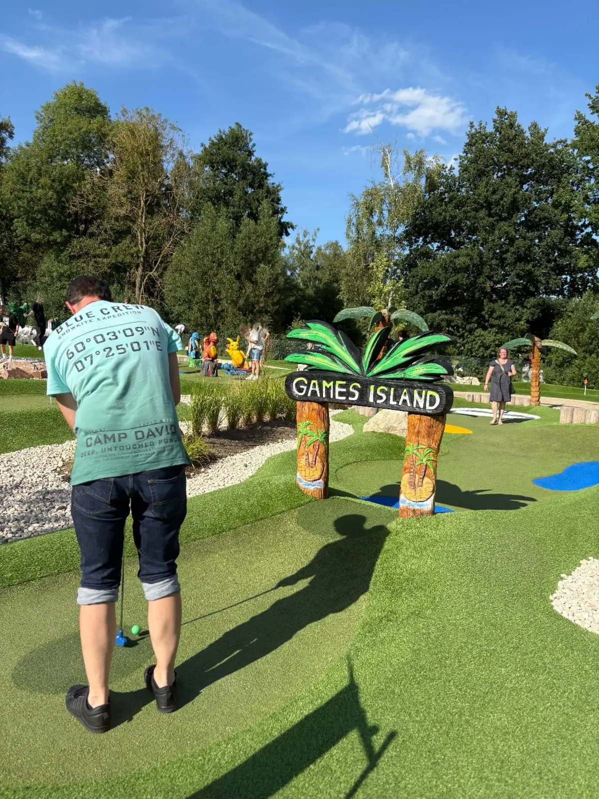Ein Kollege setzt beim Minigolf zum Schlag an